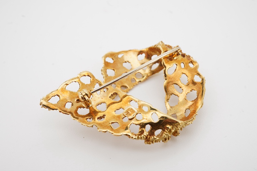 A 1970's textured yellow metal (stamped 750) brooch, 44mm, 11.9 grams. Condition - good